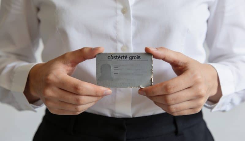 Employe administratif posant une vieille carte grise